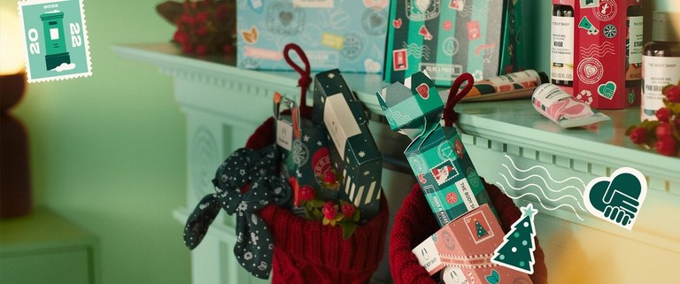 Christmas stockings filled with the body shop gifts hanging from the mantle piece