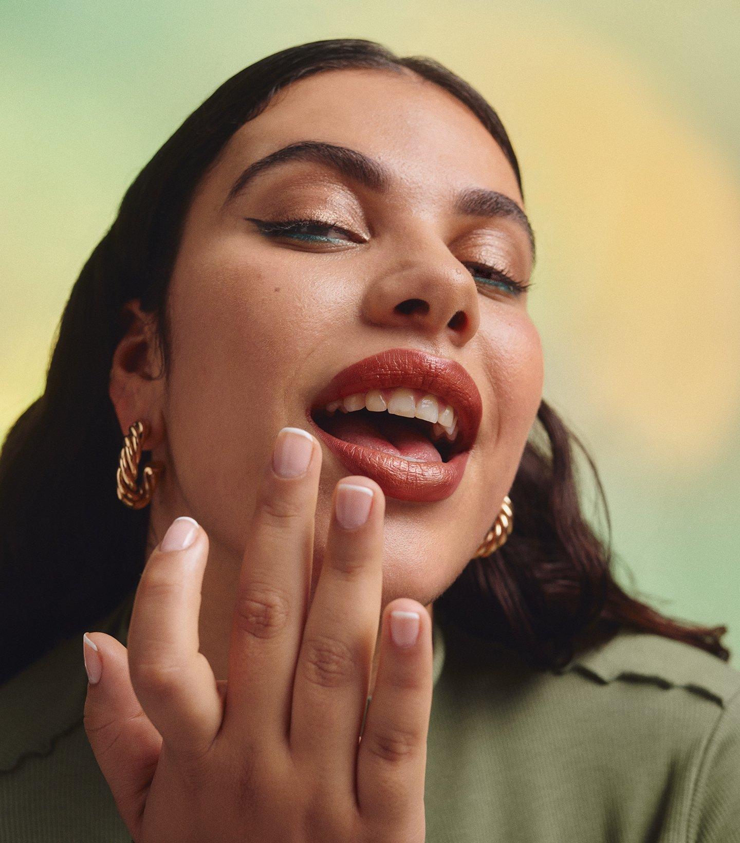 Model applying lipstick with finger