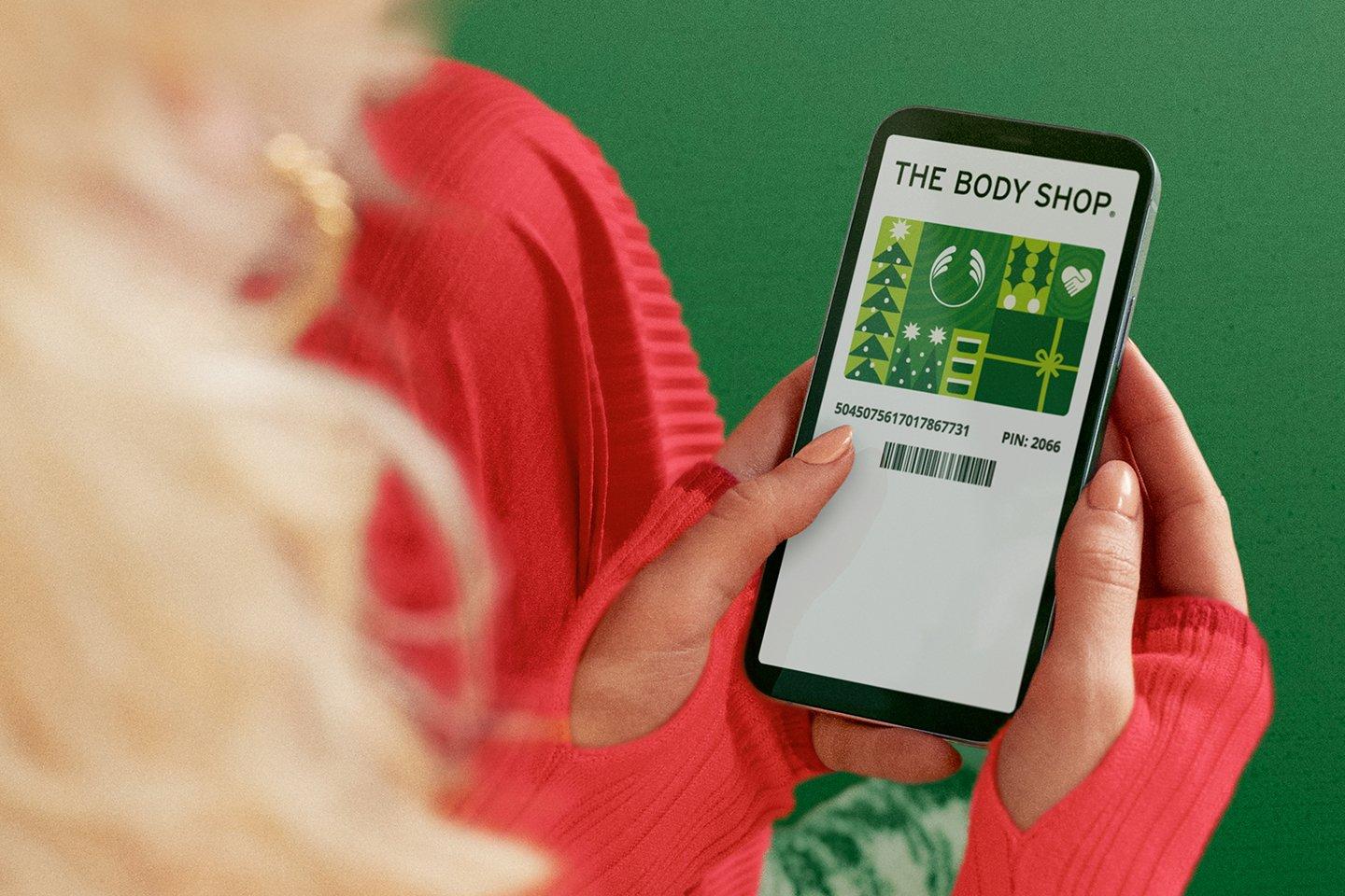 Girl looking at mobile The Body Shop gift card