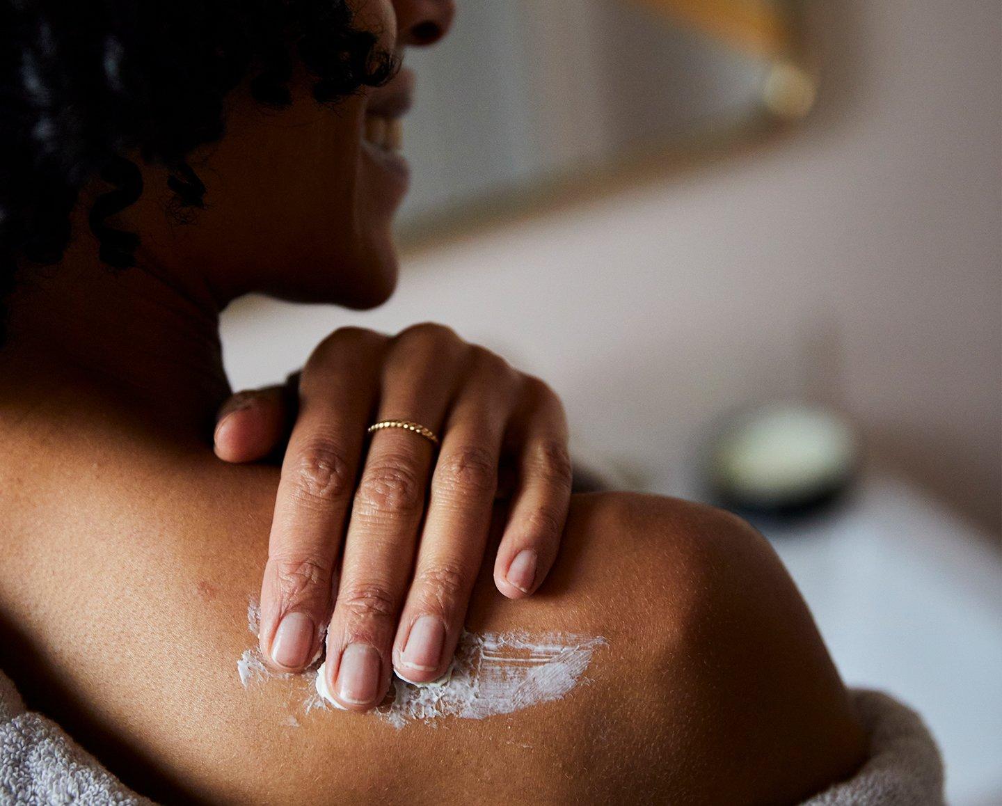 lady massaging shoulder with cream