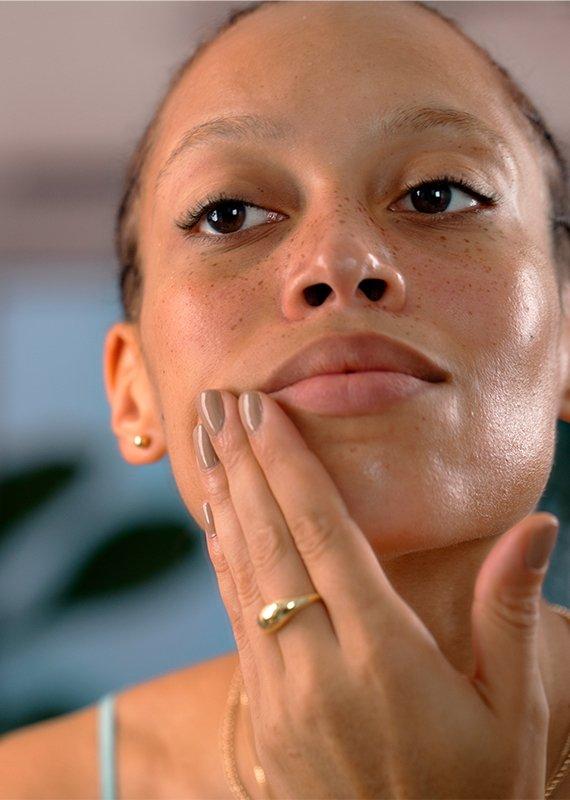 Woman moisturising face