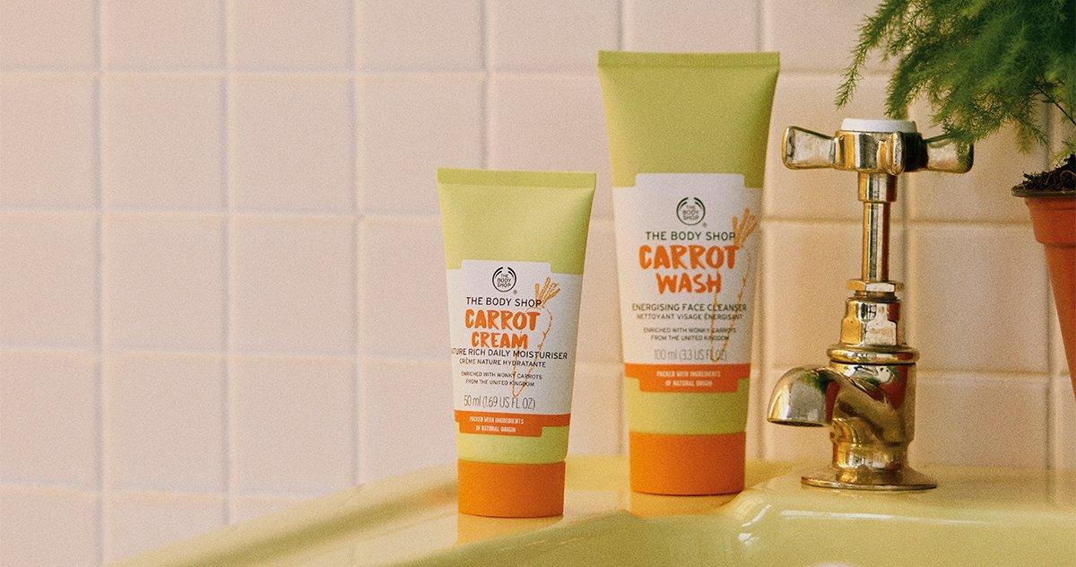 Carrot skincare range on green bathroom sink against a white tiled background