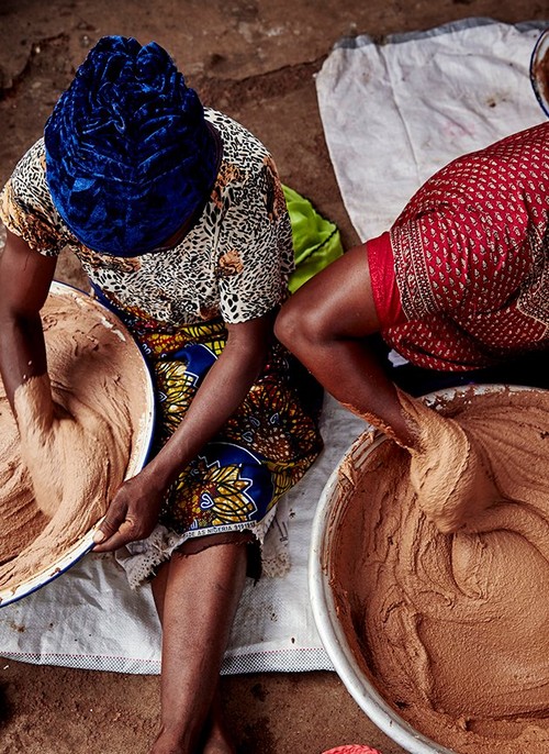 Two women mixing shea butter Two women mixing shea butter