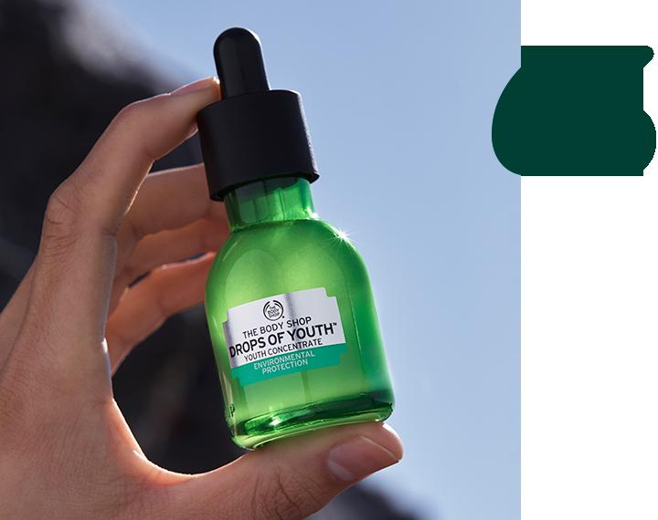 Model holding Drops of Youth concentrate with two green quotation marks next to it
