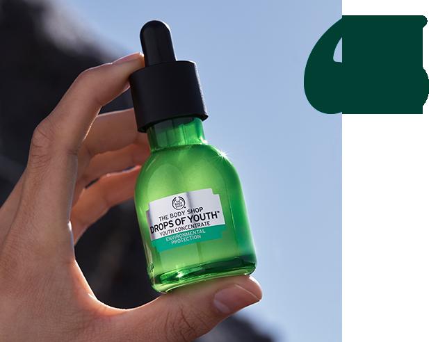 Model holding Drops of Youth Concentrate with a green quotation mark next to it