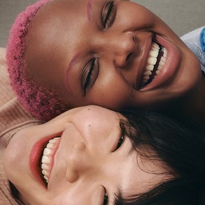Two models smiling next to each other Two models smiling next to each other
