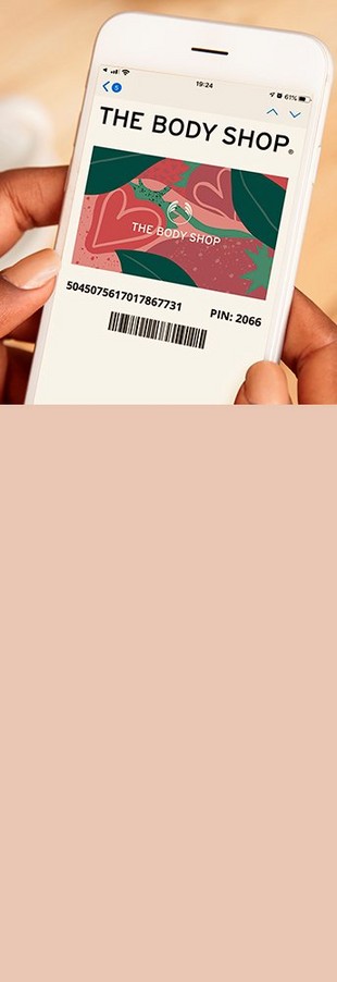 Woman holding phone. On the screen there is a pink floral The Body Shop gift card. Woman holding phone. On the screen there is a pink floral The Body Shop gift card.