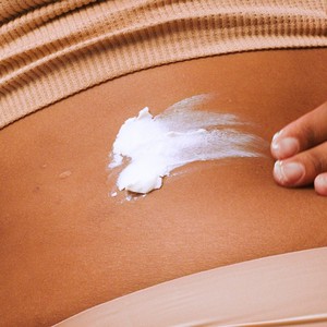 Model applying body butter to skin Model applying body butter to skin