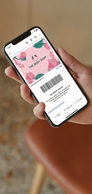 Person holding a smartphone with a Mother's Day e-gift card on the screen Person holding a smartphone with a Mother's Day e-gift card on the screen