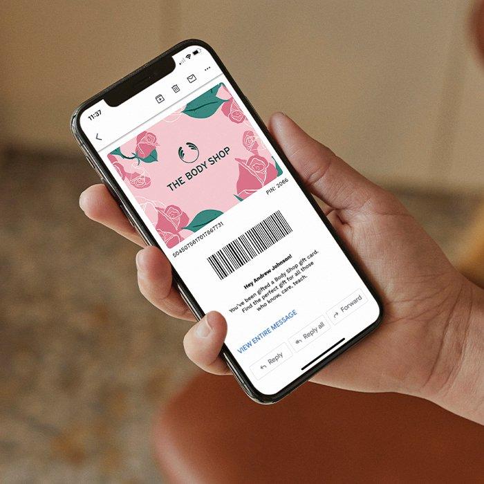 A hand holding The Body Shop e-gift card for Mother's Day