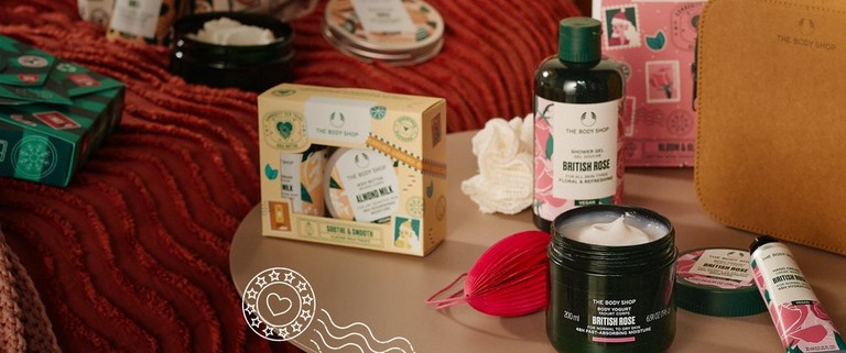 Image of various The Body Shop gifts and products, with Community Fair Trade illustrated postal image