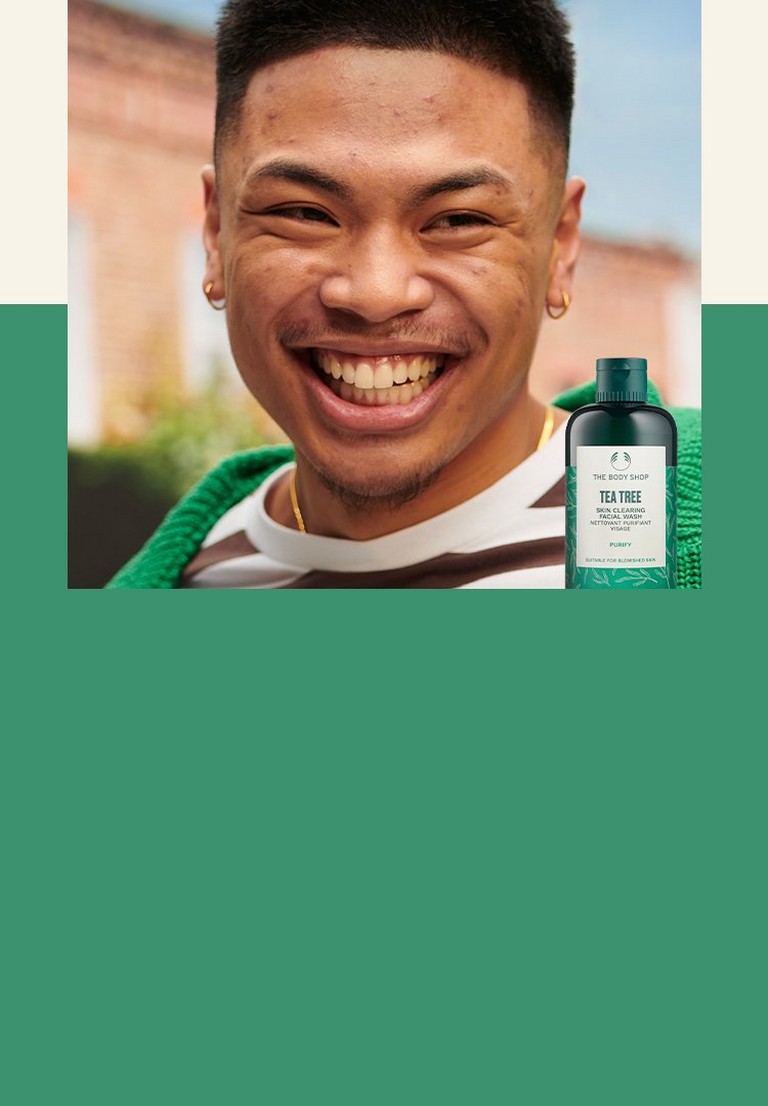 The Body Shop Tea Tree Facial Wash montré près d'une personne souriante