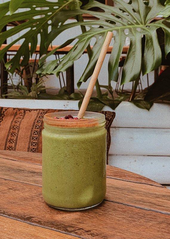 Green smoothie on brown wood surface