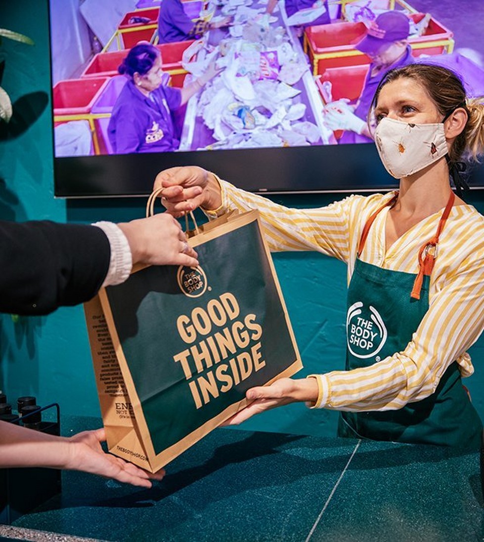 The Body Shop Employee handing customer their purchase The Body Shop Employee handing customer their purchase