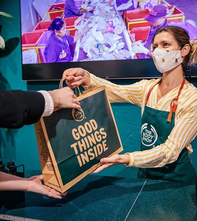 The Body Shop Employee handing customer their purchase