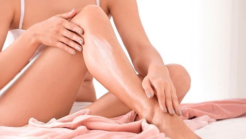 Woman applying cream to her legs Woman applying cream to her legs