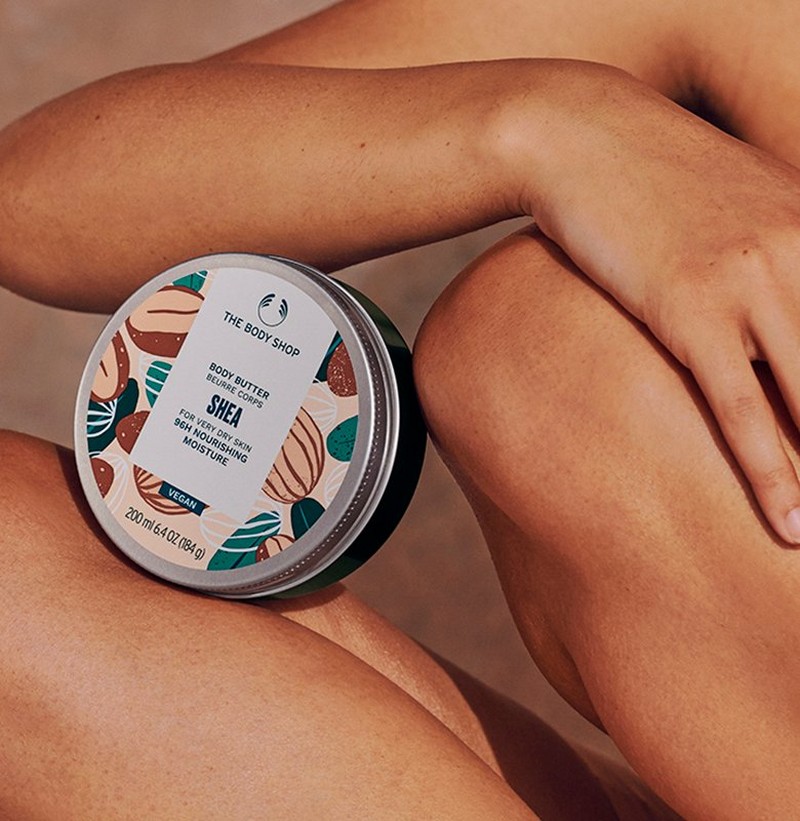 Frau, die Shea Body Butter mit Arm und Beinen hält Frau, die Shea Body Butter mit Arm und Beinen hält