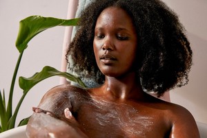 Woman applying The Body Shop Almond Scrub Woman applying The Body Shop Almond Scrub