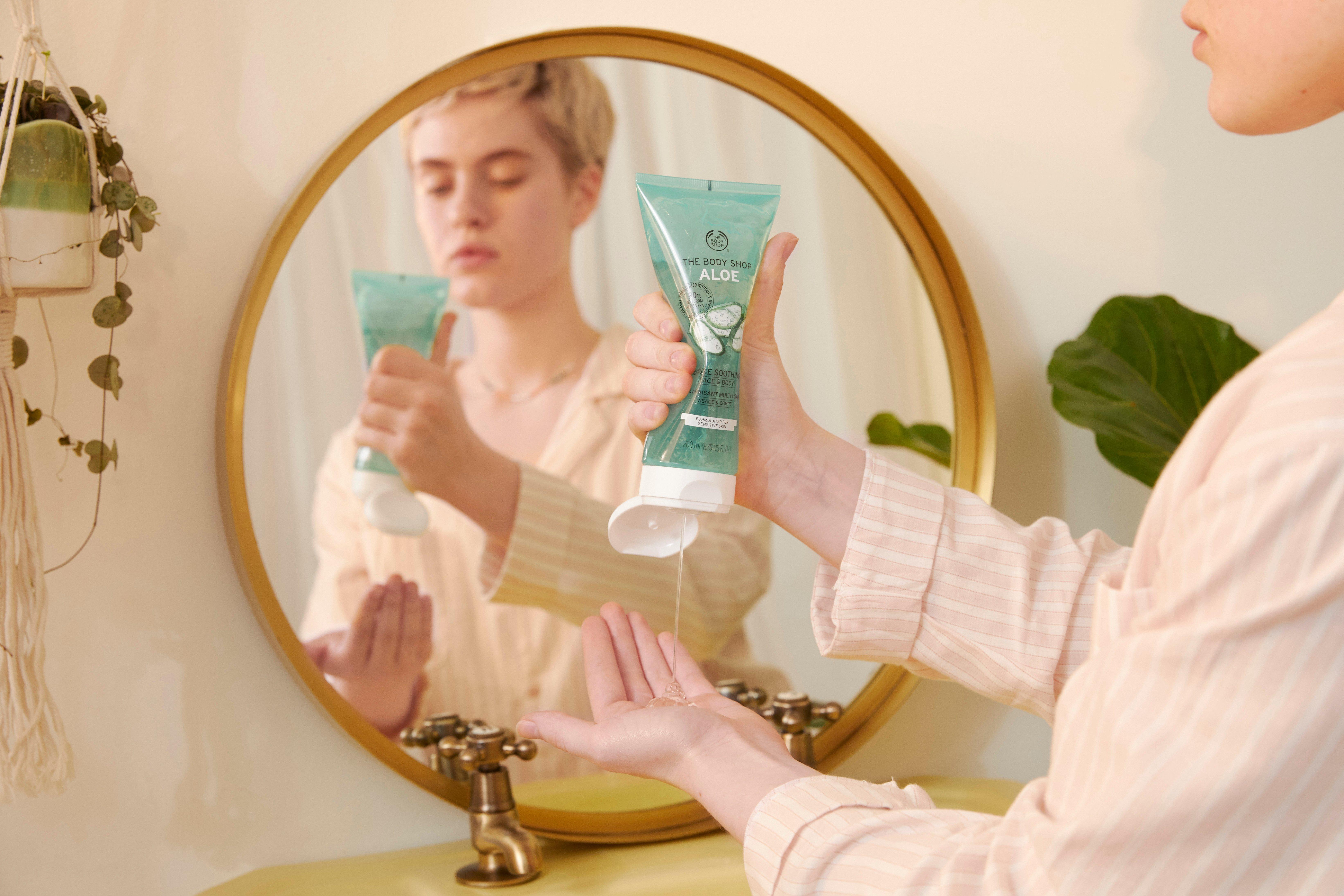 Woman squeezing Aloe soothing gel into her hands
