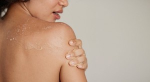 Woman applying body scrub Woman applying body scrub