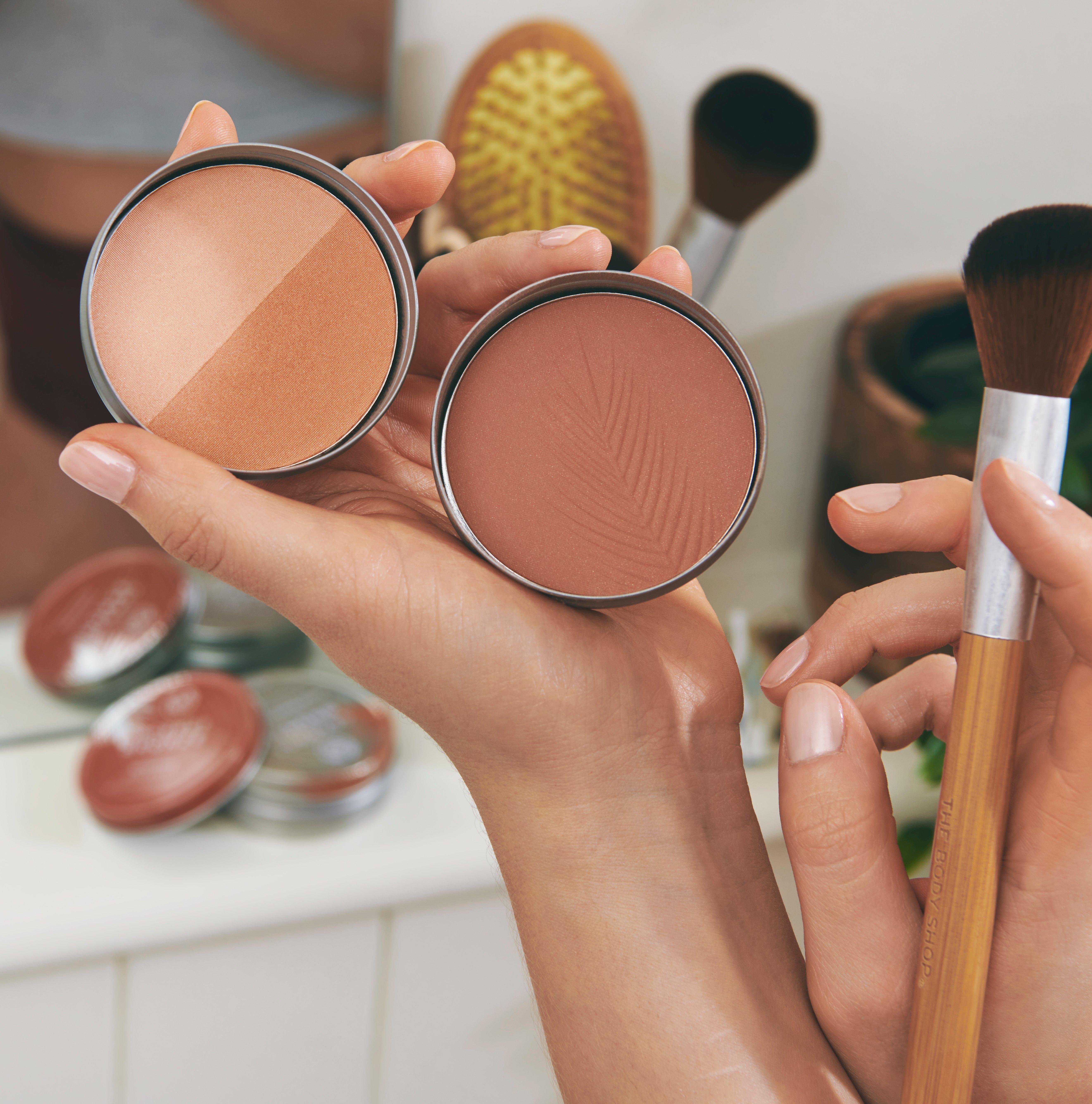 Person holding makeup and brush