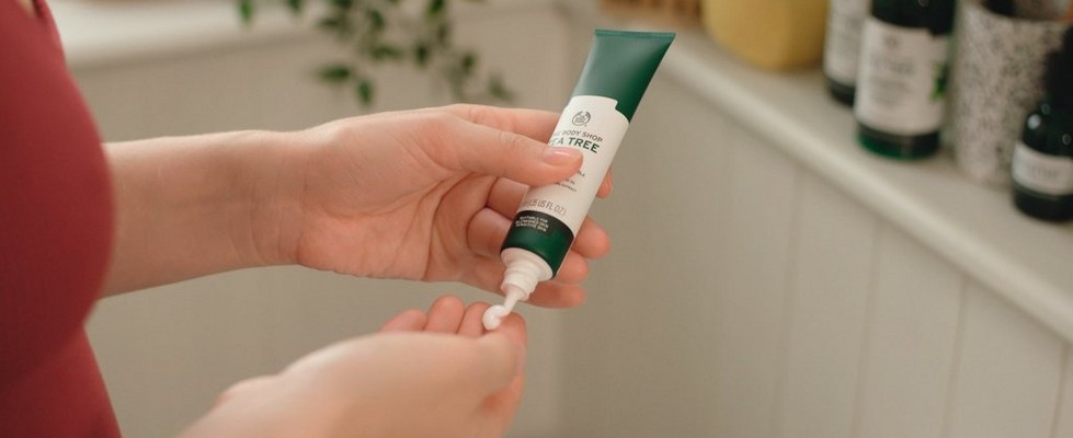 Des mains serrant un tube d’hydratant visage Des mains serrant un tube d’hydratant visage