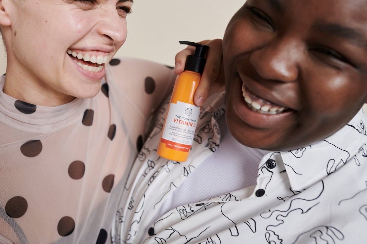 Ladies laughing with The Body Shop Vitamin C product