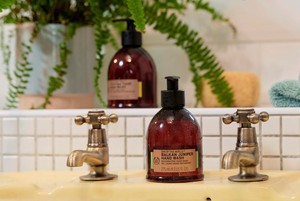 Der Spa-Handreiniger von The Body Shop auf dem Waschbecken Der Spa-Handreiniger von The Body Shop auf dem Waschbecken