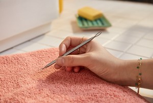 Una mano sosteniendo un quitaespinillas Una mano sosteniendo un quitaespinillas