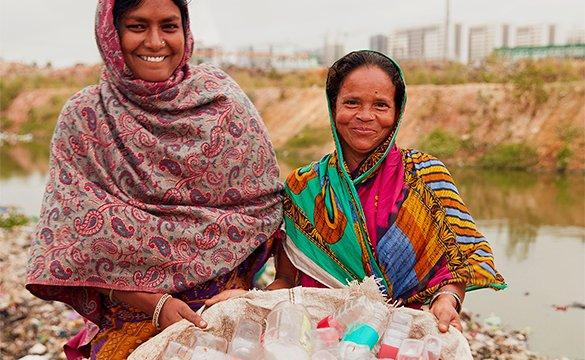 Two women holding plastic bottles