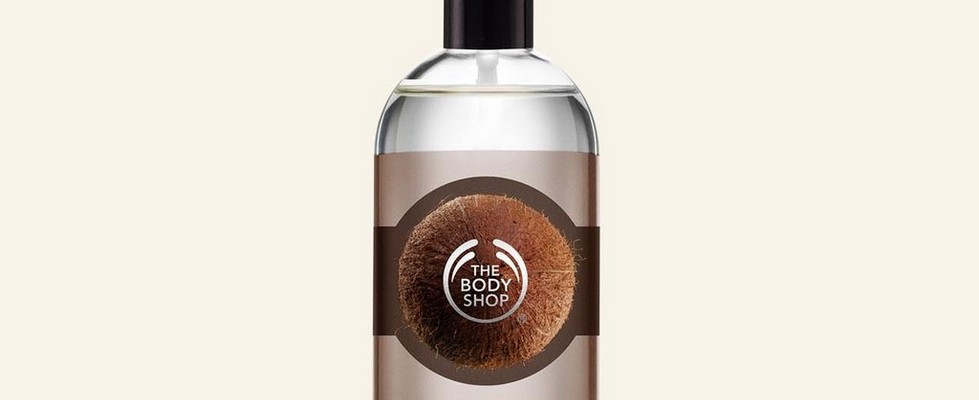 Coconut body mist against beige background Coconut body mist against beige background