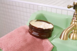 Burk med Body Shop Coconut Body Butter på ett handfat Burk med Body Shop Coconut Body Butter på ett handfat