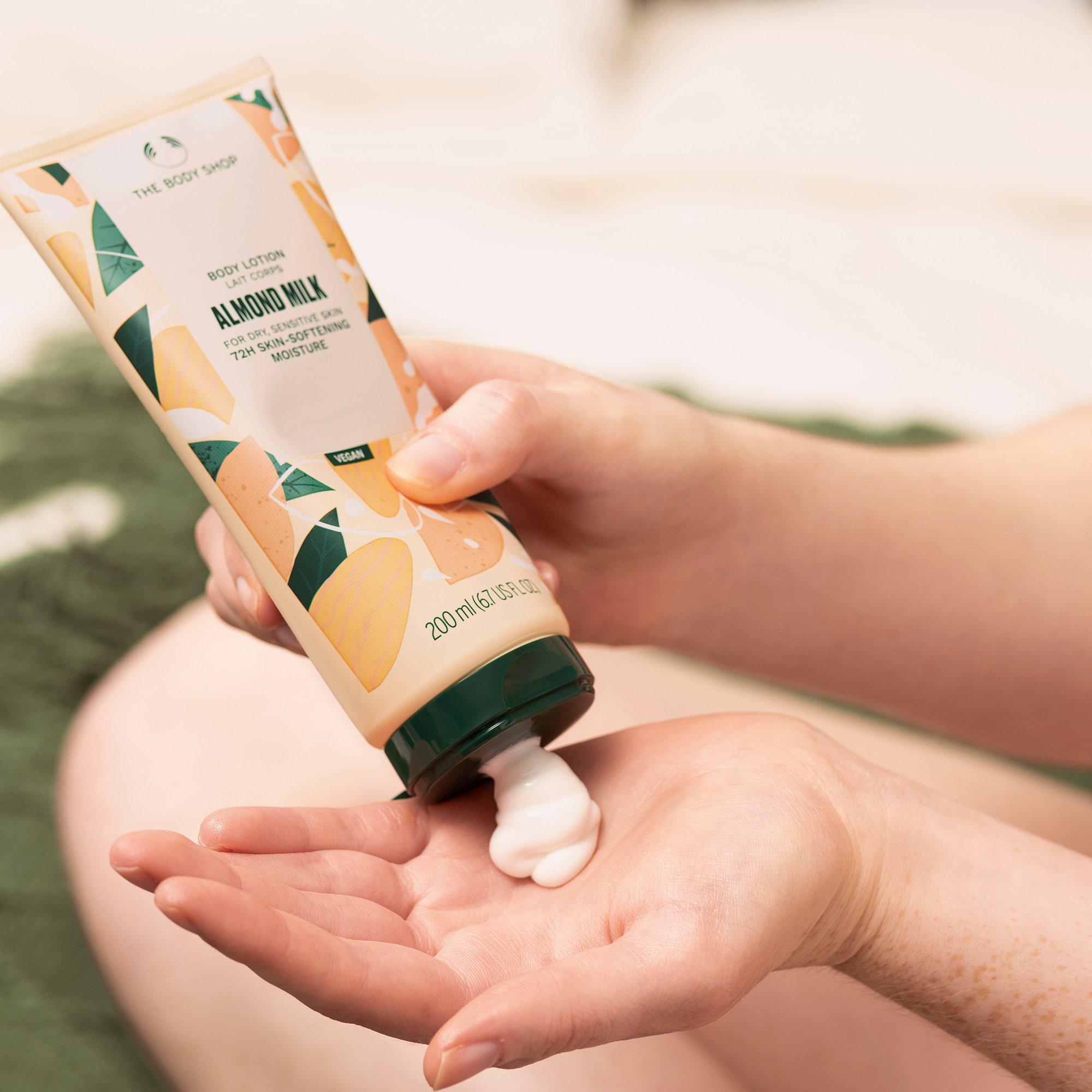 Woman in a bath applying moisturiser