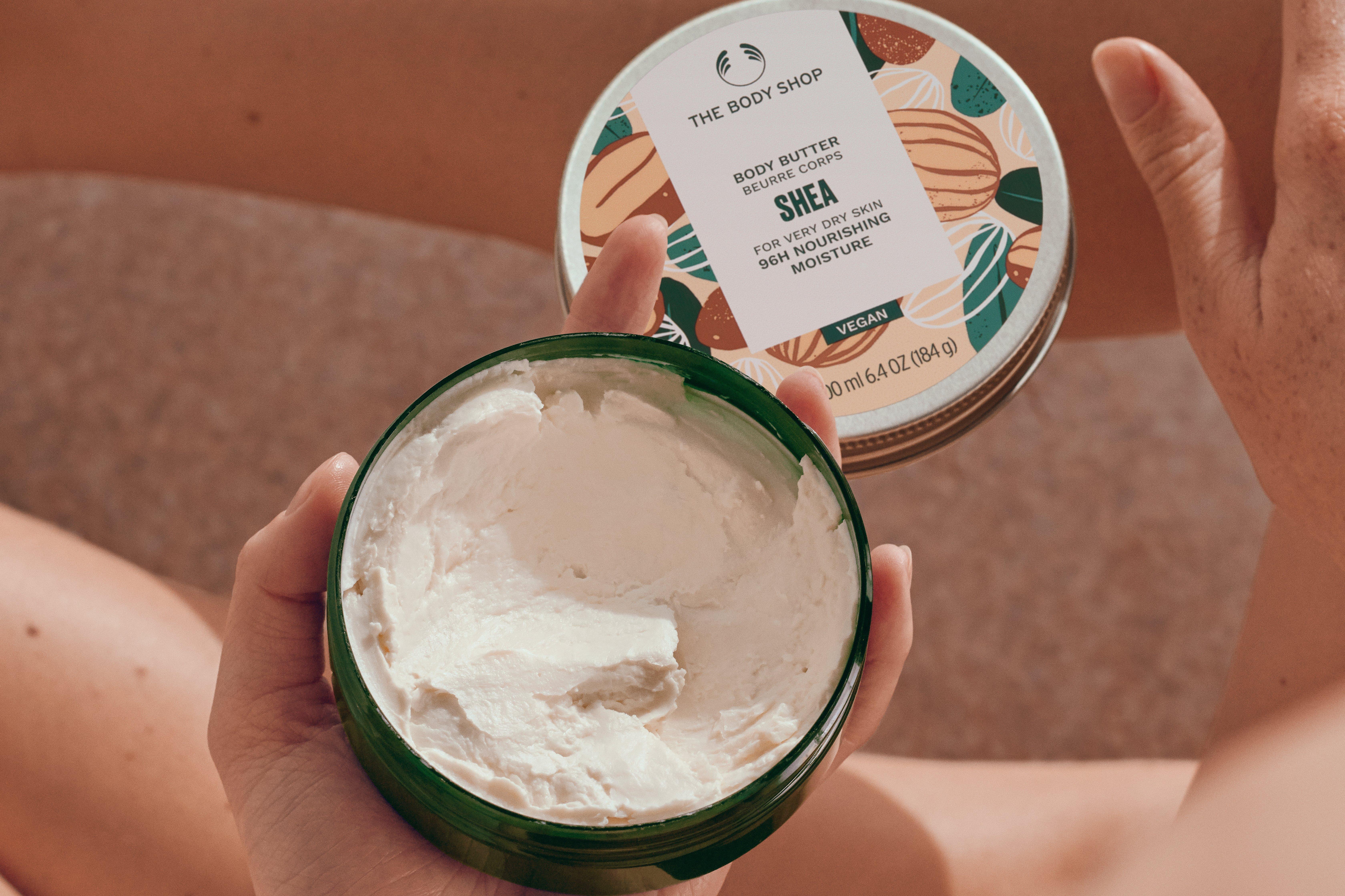Woman scooping The Body Shop Hemp Body Butter from tub
