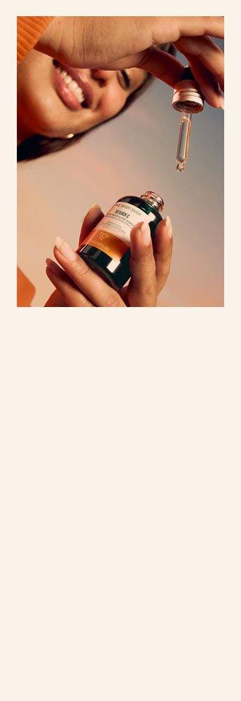 Model holding bottle of Vitamin C Glow Serum