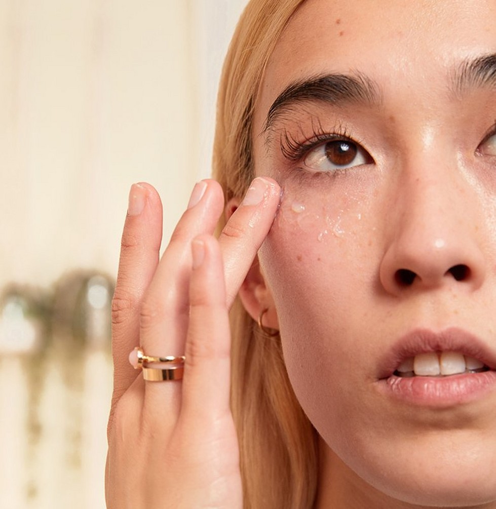 Model applying eye cream Model applying eye cream