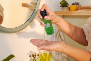 Unas manos dosifican Peeling Líquido Drops of Youth™ de The Body Shop Unas manos dosifican Peeling Líquido Drops of Youth™ de The Body Shop