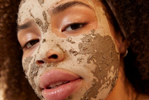 Woman with Charcoal face mask on her skin