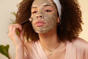Woman applying The Body Shop Himalyana Charcoal mask