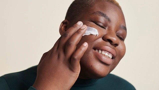 Person applying cream to face