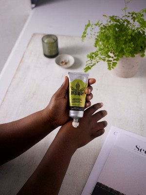 Des mains qui pressent le tube de crème protectrice pour les mains au chanvre Des mains qui pressent le tube de crème protectrice pour les mains au chanvre