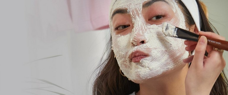 Model applying face mask with a brush