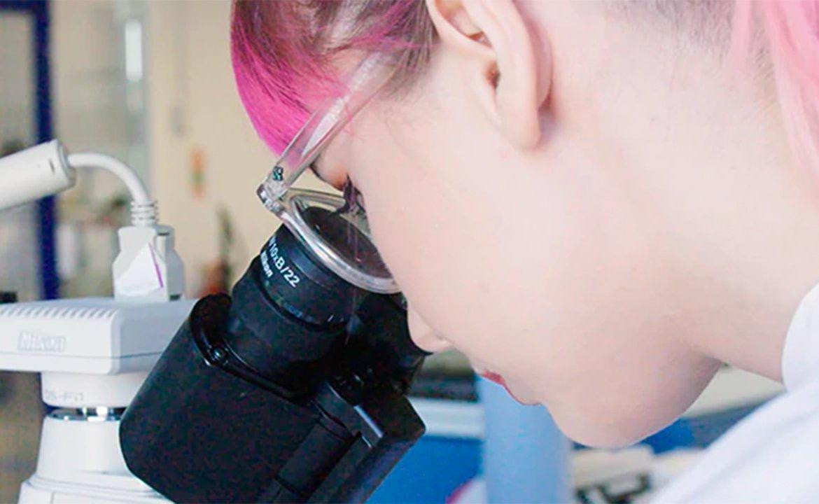 Une femme regardant dans un microscope