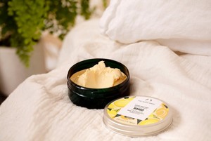 Woman scooping The Body Shop Hemp Body Butter from tub Woman scooping The Body Shop Hemp Body Butter from tub