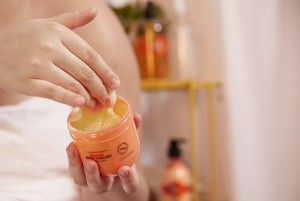 Une main plongeant dans le Body Yogurt Mangue The Body Shop Une main plongeant dans le Body Yogurt Mangue The Body Shop