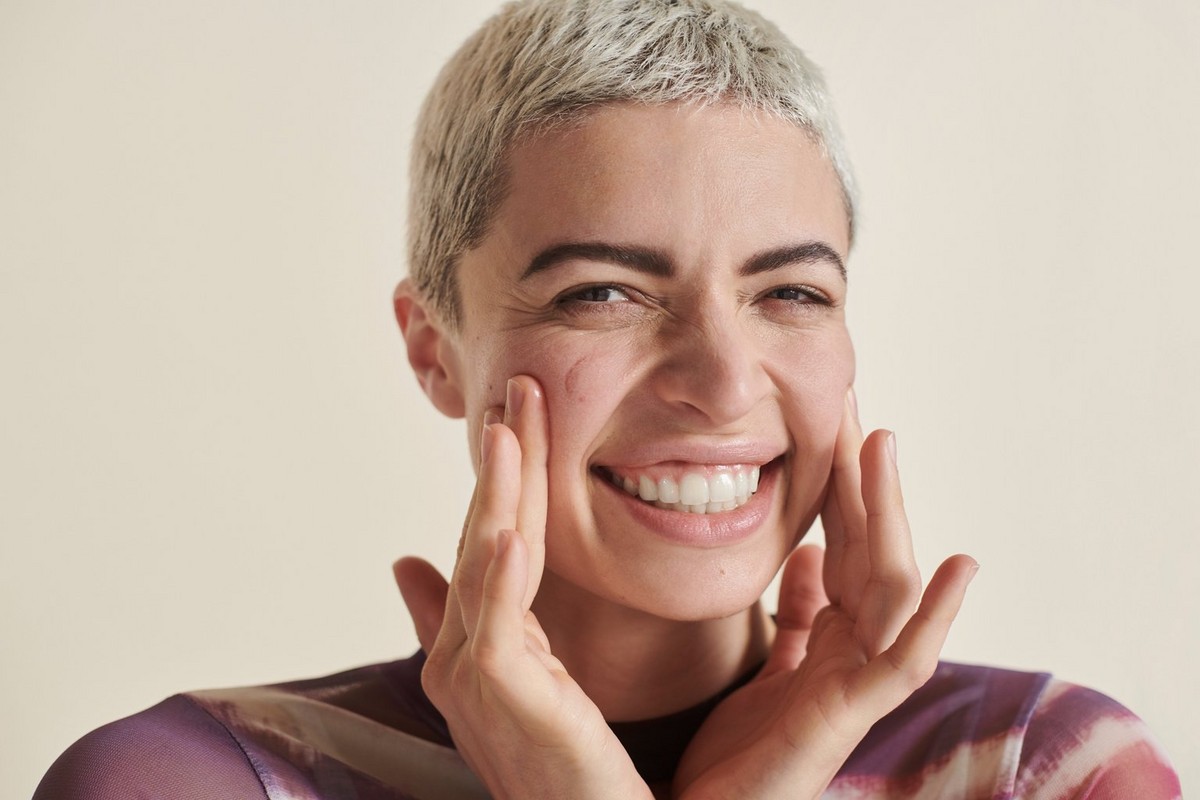 woman smiling with her hands on her cheeks