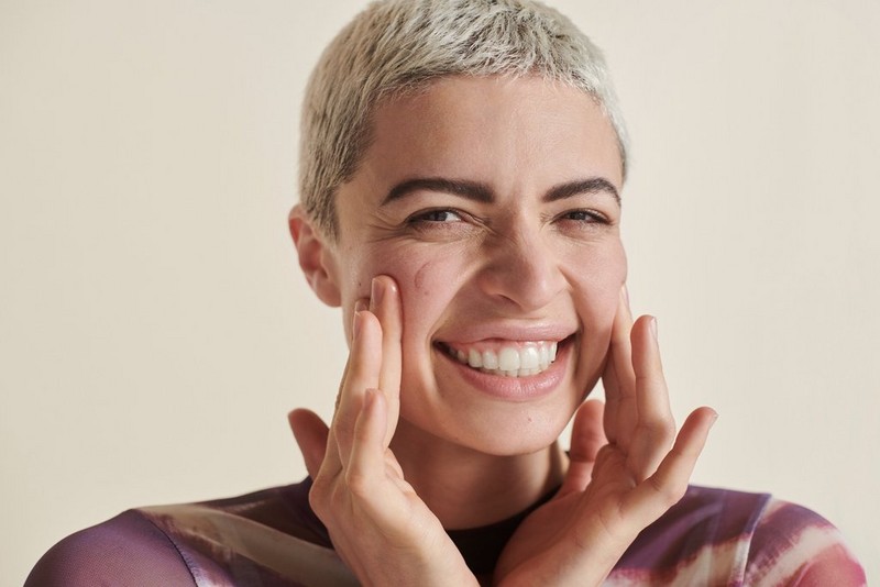 woman smiling with her hands on her cheeks woman smiling with her hands on her cheeks