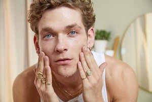 Un hombre se aplica exfoliante facial Un hombre se aplica exfoliante facial