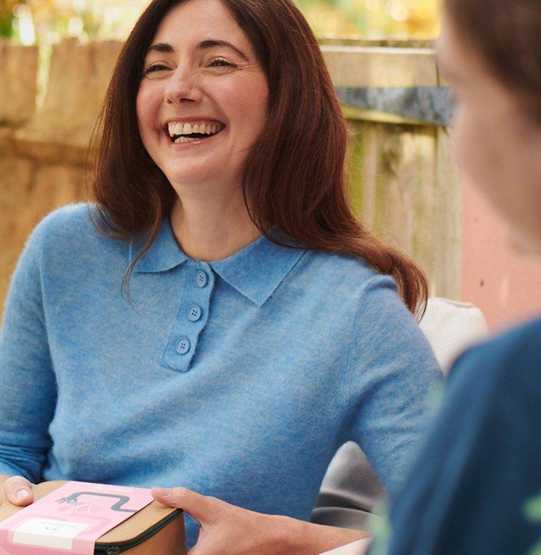 Women holding gift and smiling