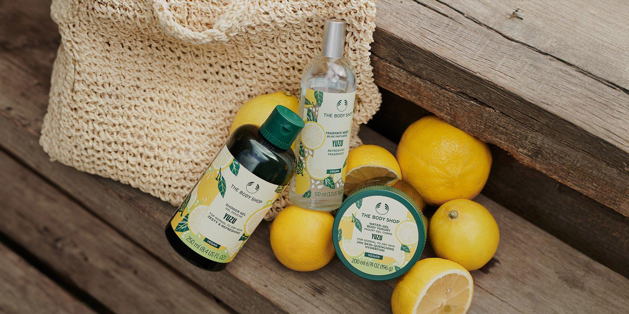 a bag of lemons and body care yuzu products on a wooden bench